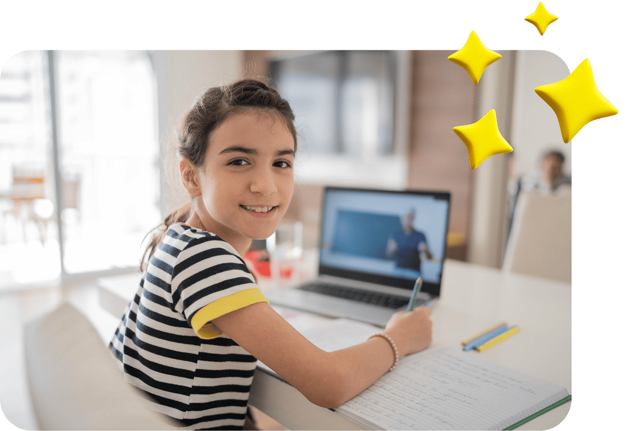 Una niña sonriente con una camisa a rayas escribe en un cuaderno mientras mira una computadora portátil. La pantalla muestra una conferencia en línea. Ambiente luminoso y alegre.