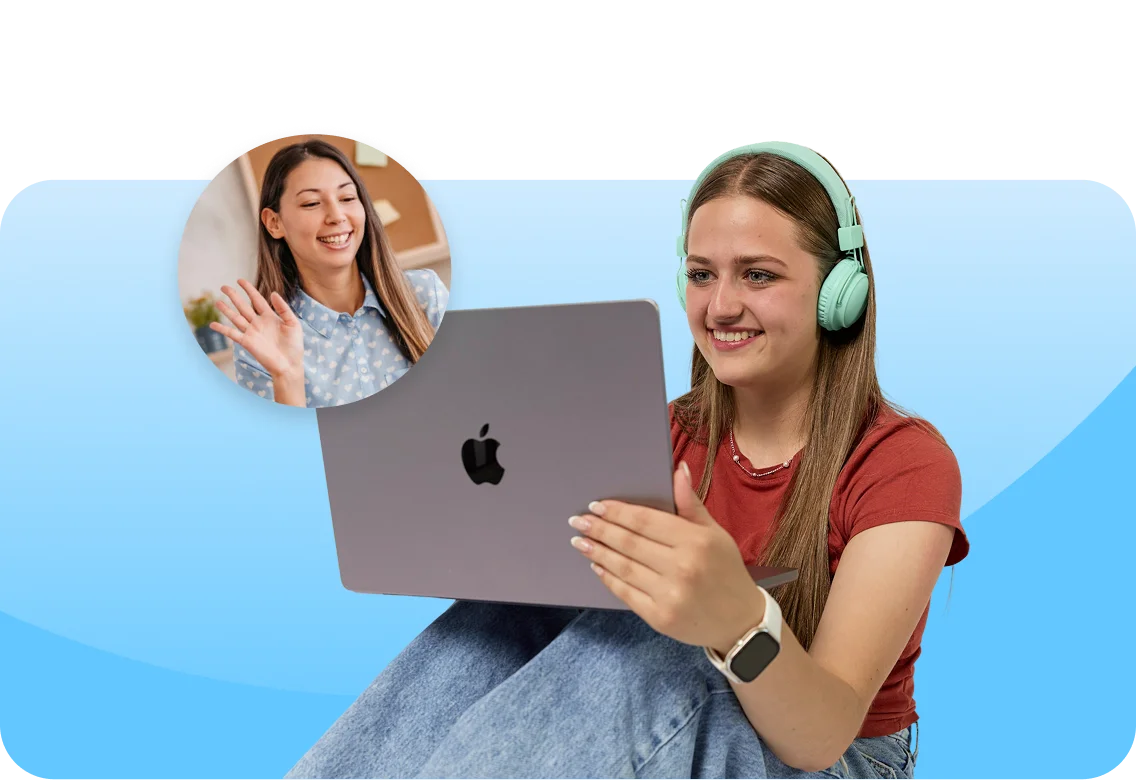 A woman with headphones smiles at a laptop, engaging in a video call. Another woman waves from a small inset circle. The scene is cheerful and connected.