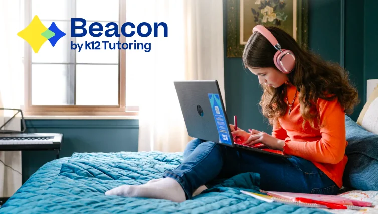 Learner using a laptop and taking notes during an online tutoring session, with the Beacon by K12 Tutoring logo highlighting personalized academic support from home.