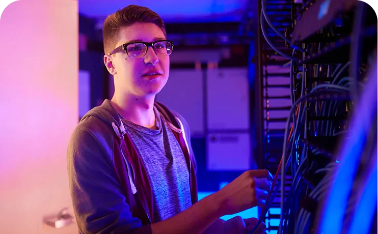 Information technology student working with network infrastructure and server equipment, demonstrating hands-on technical skills and career readiness.