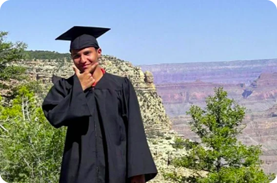 Graduate celebrating academic achievement in an outdoor setting, representing perseverance, success, and future opportunities.