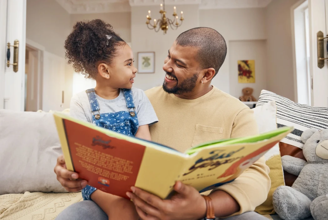 Adult and child sharing story time together, highlighting early literacy development and a love of reading.