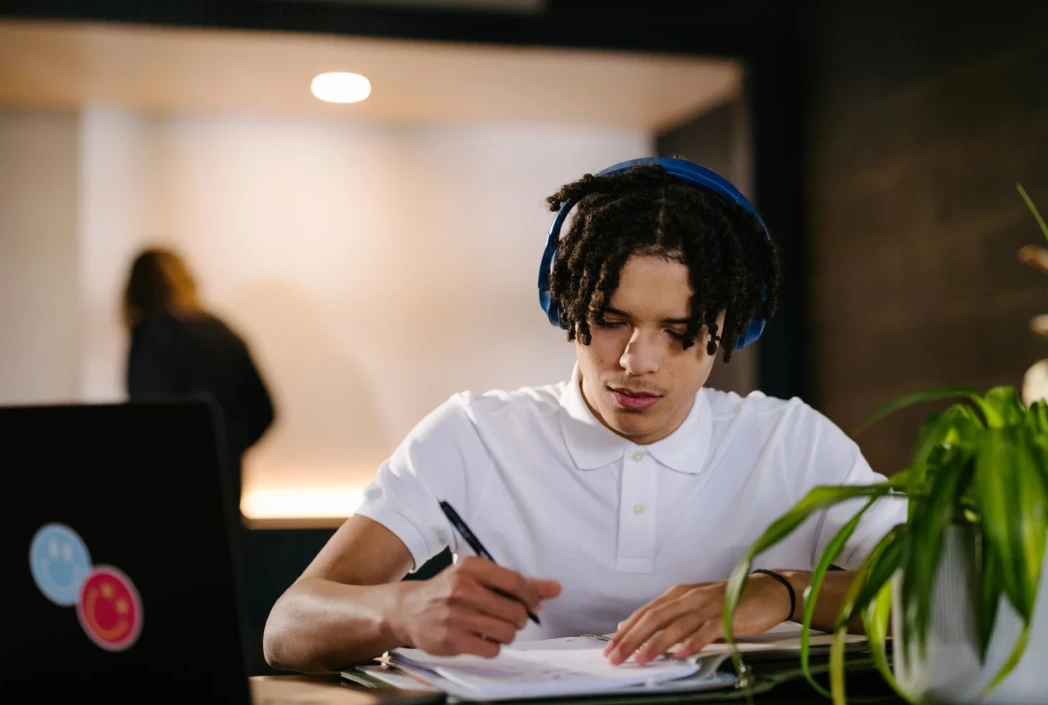 Student focused on completing assignments in a dedicated study area, demonstrating healthy homework habits and academic organization.