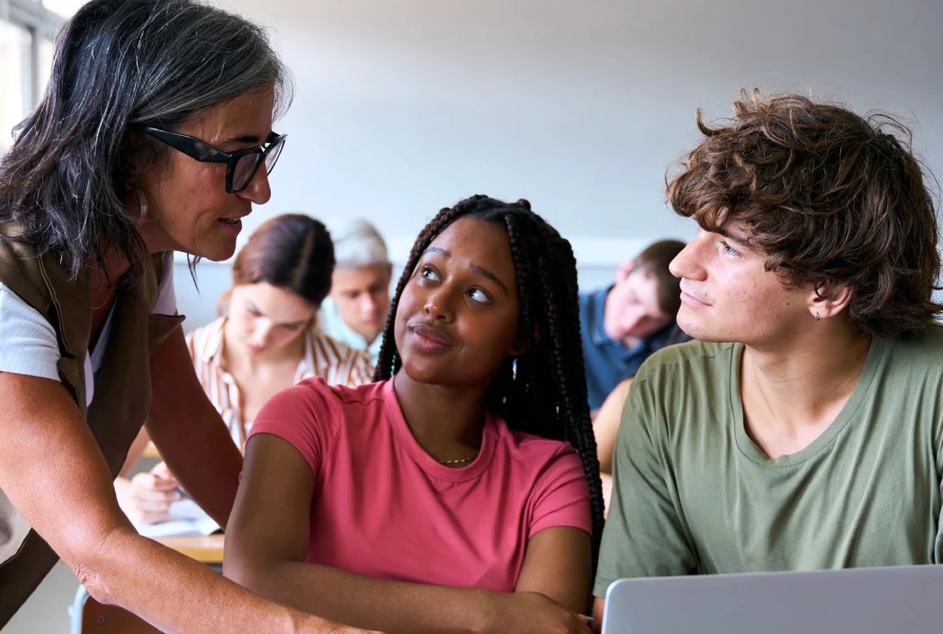 Instructor providing guidance to students during a collaborative classroom activity, highlighting engagement, communication, and student participation.