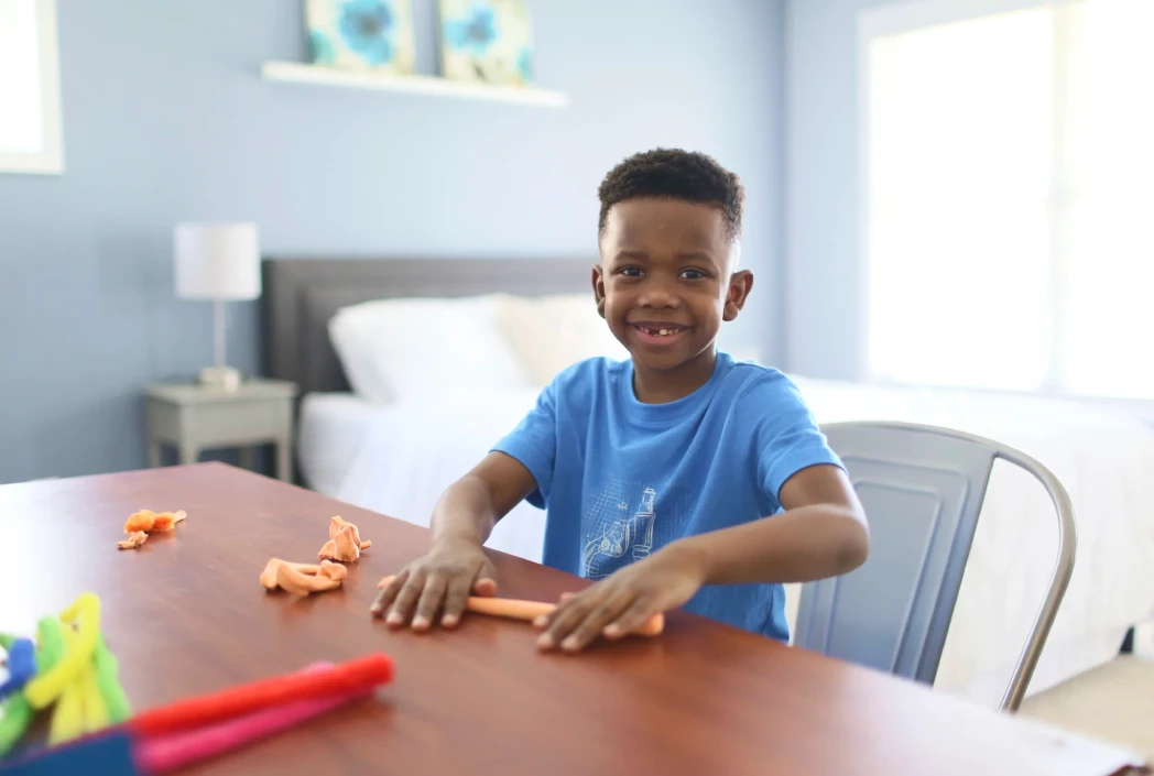 Young learner developing creativity and fine motor skills through a hands-on modeling clay activity.