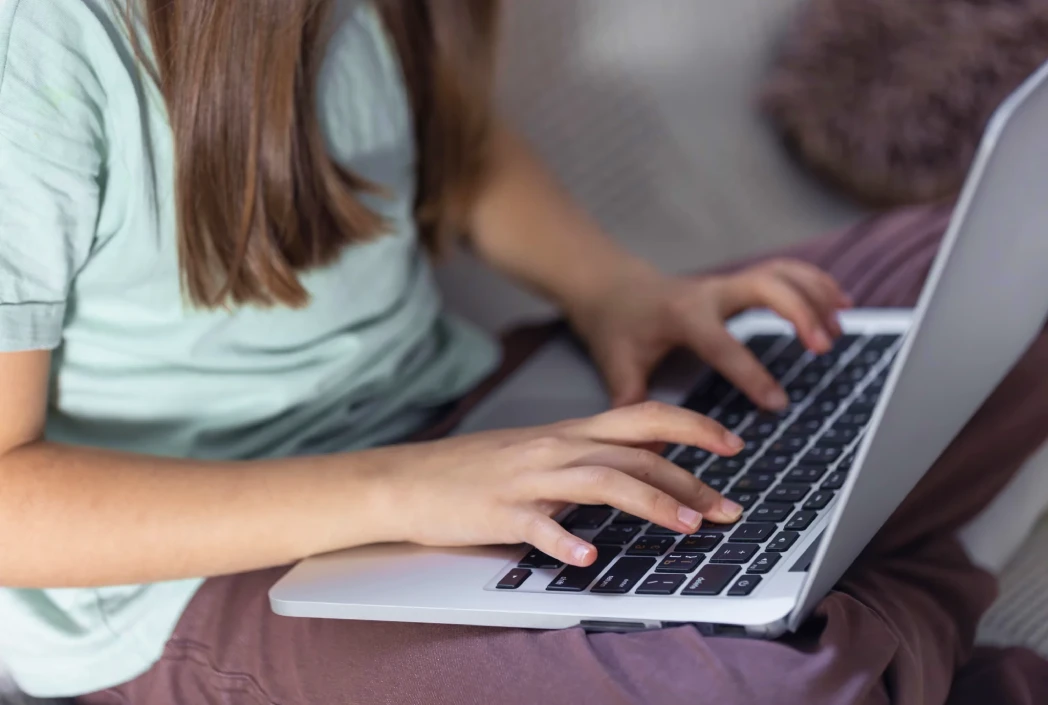 Student using a laptop for online learning, highlighting digital readiness and access to educational technology.