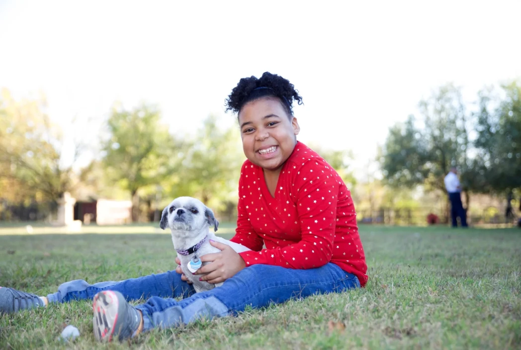 Student enjoying time outdoors with a pet, highlighting the importance of balance, relaxation, and well-being alongside academic success.