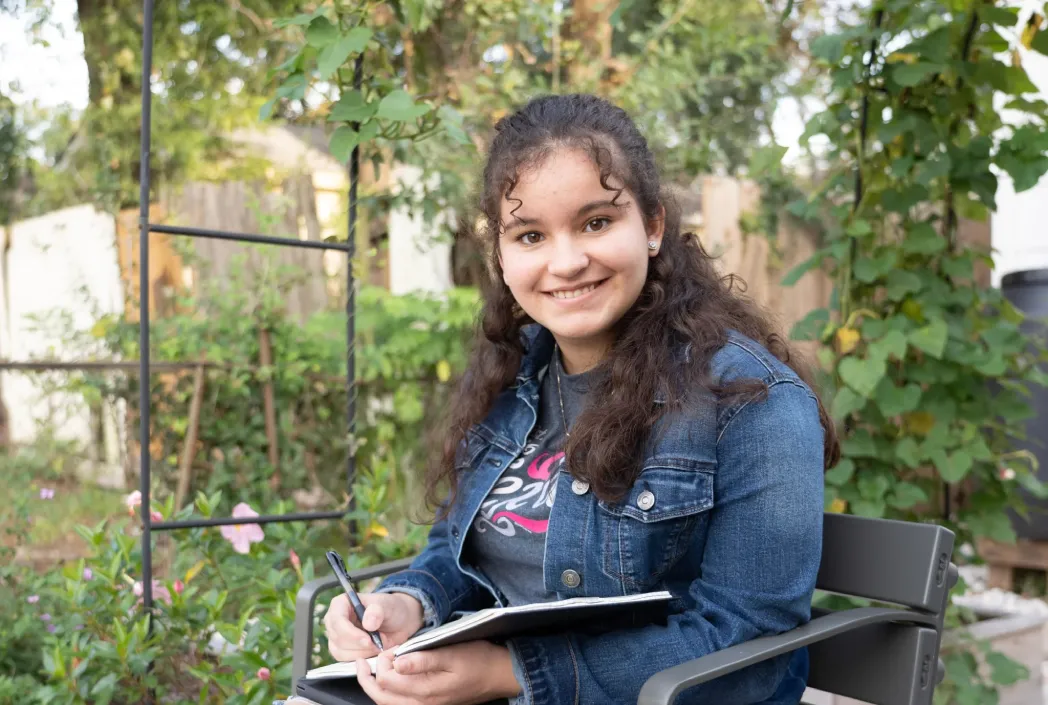 Student studies outdoors with a notebook, highlighting the freedom to learn anytime, anywhere through flexible online education.